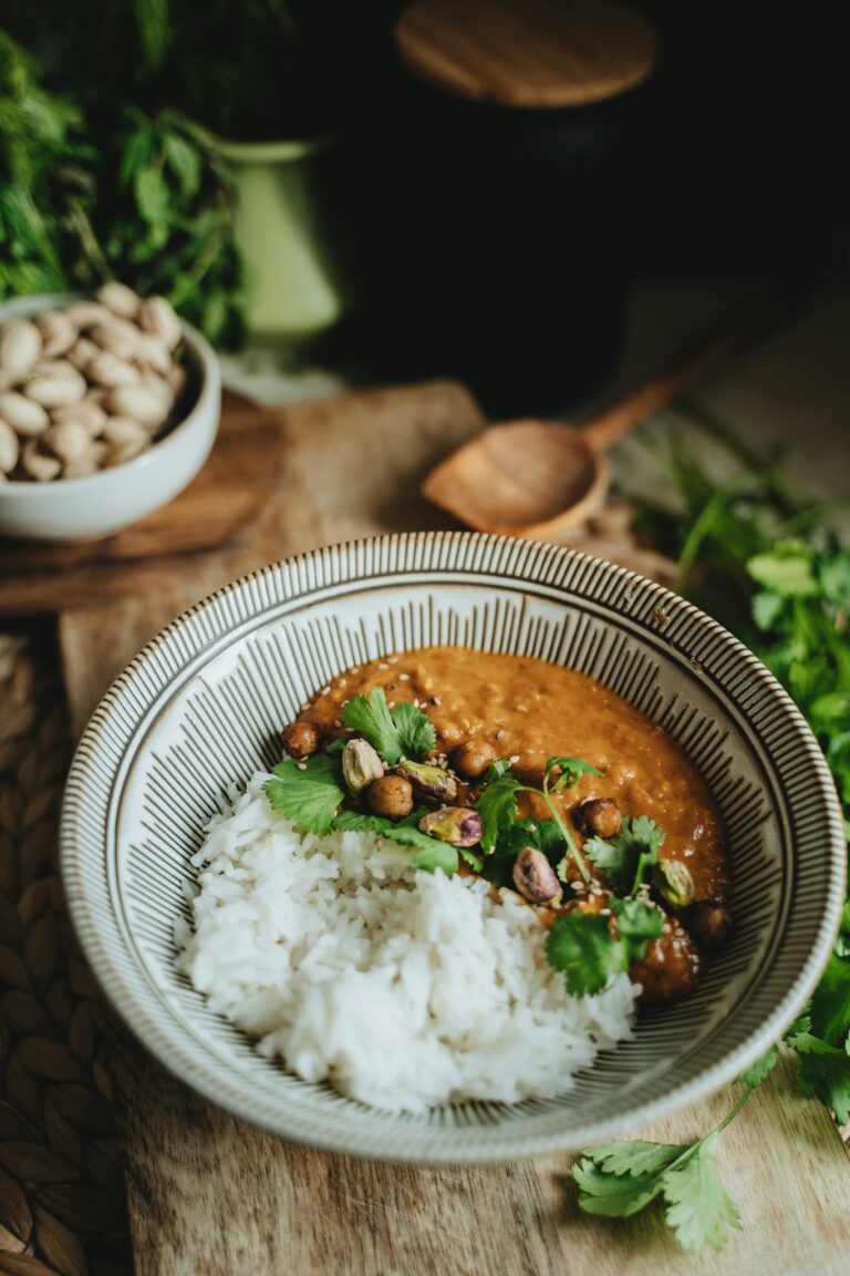 A bowl of vegan lentil curry with rice garnished with cilantro, perfect for a healthy meal.